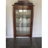 An Edwardian decorated mahogany display cabinet with a bow fronted leaded glazed door, 139cm tall