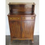 A Regency style mahogany side cabinet with a gallery top and two drawers over two cupboard