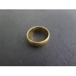 A 22ct yellow gold hallmarked band ring, size N, approx 5.8 grams, some usage marks but generally