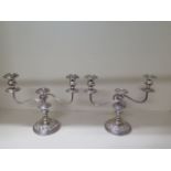 A pair of silver plated twin branch candelabra, 28cm tall x 36cm wide, generally good, dent to one