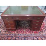 An Edwardian mahogany partners twin pedestal desk with a leather inset top and nine drawers with