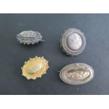 Three silver brooches and a gilt brooch