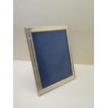 A silver presentation photo frame with mahogany easel back 28cm x 21cm, in good condition