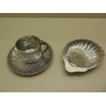 A silver shell dish and a continental white metal cup and saucer, total weight approx 4.7 troy oz,