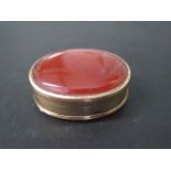 A gilt metal carnelian oval snuff pill box, 45mm x 33mm x 19mm tall, in good condition, shuts