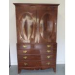 A Georgian mahogany linen press with two door top enclosing a slide and a shelf above a four