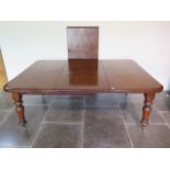 A 19th century mahogany pullout dining table with two leaves on turned carved legs, 71cm tall x