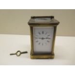 A brass carriage clock striking on a gong, 13cm tall, glass good, running with key