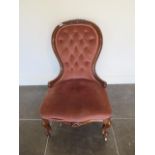 A Victorian carved walnut button back fireside chair