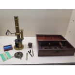 A 19th century brass field microscope with fitted mahogany box and five prepared slides, in