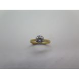A diamond solitaire ring comprising a round brilliant cut diamond set in six claws to a white