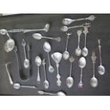 A pair of silver nips and a collection of silver and white metal spoons and other flatware, total