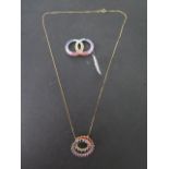 A 9ct yellow gold rainbow sapphire spiral pendant on chain and a white gold rainbow sapphire