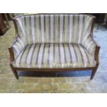 An Edwardian mahogany settee which has been reupholstered in a stripped material, 88cm tall x