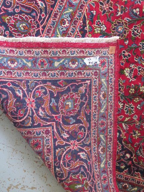 A hand woven large red ground Persian woollen Kashan carpet, 405cm x 284cm, some wear consistent - Image 6 of 6