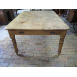 A Victorian stripped pine table with two end drawers and a side drawer on turned legs, 77cm tall x