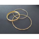 An Eastern gold child's bangle, 5.3cm external diameter, an Eastern gold bangle 7.3cm diameter,