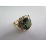 A hallmarked 18ct yellow gold ring with a centre green stone possibly Tourmaline surrounded by small