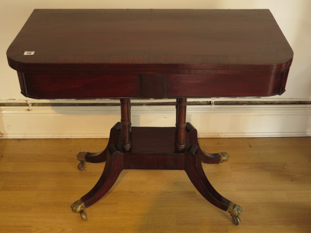 A 19th century mahogany foldover card table on four pillar support and splayed legs on brass hairy