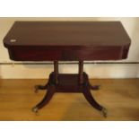 A 19th century mahogany foldover card table on four pillar support and splayed legs on brass hairy