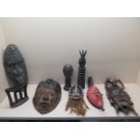 An African carved headrest 14cm x 15cm, a collection of five carved head masks and two carved