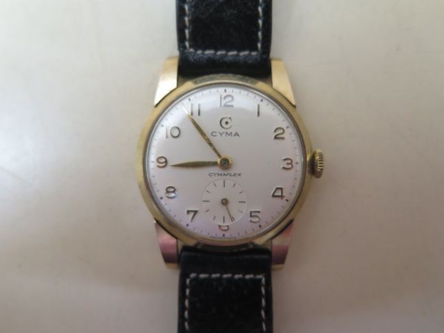 A Cyma 9ct gold Cymaflex manual wind wristwatch with 30mm case on a black leather strap, running and