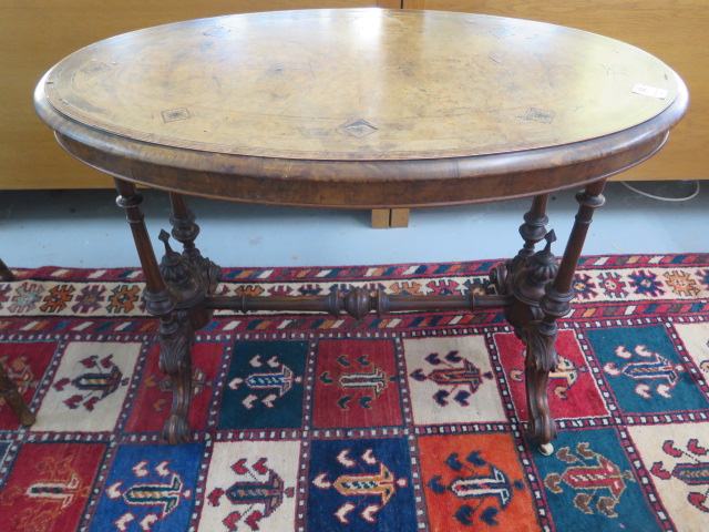 A Victorian inlaid stretcher table on turned pillar supports, 70cm tall x 99cm x 55cm, some losses