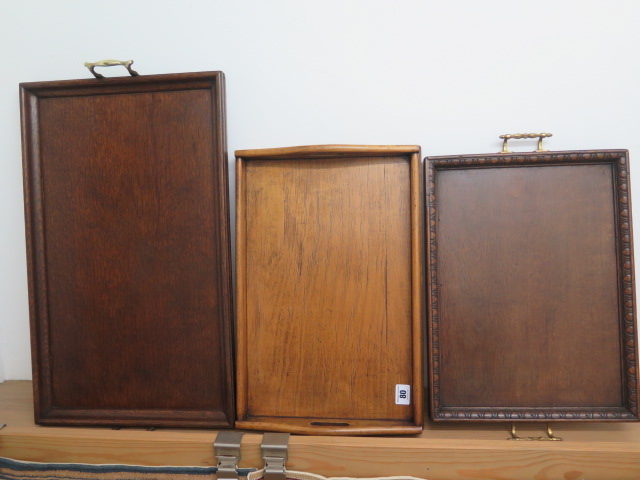 Three Edwardian oak tea trays, largest 60cm x 34cm, in good polished condition
