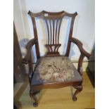 A Georgian American walnut open armchair with a vase shaped splat and scroll arms on cabriole shaped