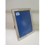 A silver presentation photo frame with mahogany easel back, 28cm x 21cm, in good condition