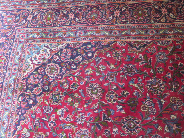 A hand woven large red ground Persian woollen Kashan carpet, 405cm x 284cm, some wear consistent - Image 4 of 6