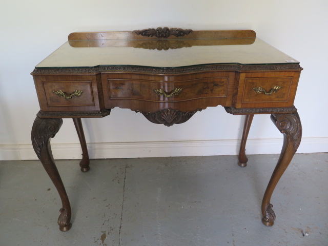 A walnut three drawer serpentine fronted table on acanthus carved cabriole legs, 90cm tall x 114cm x