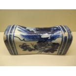 A Chinese 18th century head rest decorated in blue and white with a landscape, peony and