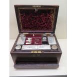 A Victorian rosewood travel box with a fitted interior of plated top bottles and tidies above a