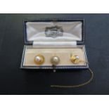 Three 9ct yellow gold pearl shirt collar studs, one with chain missing its safety clip, total weight