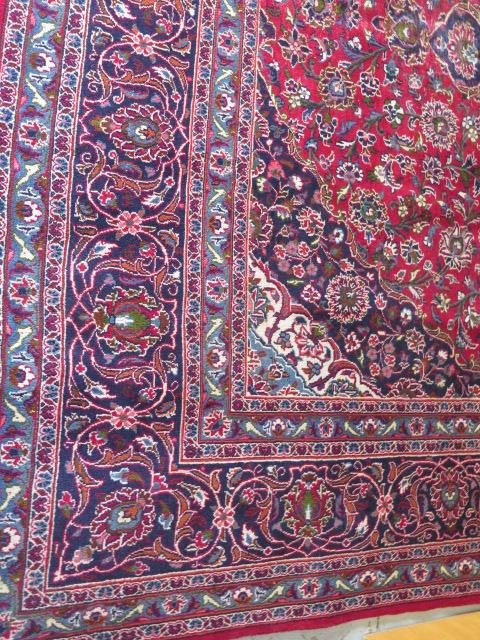 A hand woven large red ground Persian woollen Kashan carpet, 405cm x 284cm, some wear consistent - Image 5 of 6