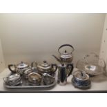 Two plated tea sets, a tray, a spirit kettle, basket, blue and white ceramic lidded pot and water