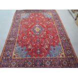 A fine hand woven teracotta ground woollen Persian Surouk full pile rug, 285cm x 200cm, in good