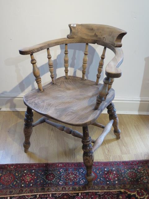 A Victorian smokers bow armchair with double turned stretchers