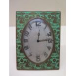 An 8 day Swiss made desk clock, 12cm x 9cm, oval dial brass case with green enamel with floral