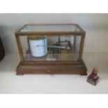 An oak cased table top Barograph by J Casartelli & Son, 43 Market St Manchester, with a base