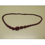 A large cherry amber type bead necklace, 72cm long, largest bead 3cm x 2.2cm, total weight approx 65