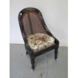 A Victorian ebonised bergere child's chair with mother of pearl inlay, 76cm tall