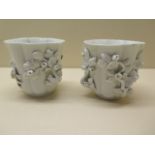 A pair of 18th century porcelain fluted cups decorated with convolulus plants and covered in a white