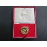 A 1986 1/2 oz fine gold 1/2 Krugerrand in a gilt metal mount, total weight approx 19.5 grams
