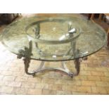 A good quality glass top table on a metal acanthus scroll base, 78cm tall x 153cm diameter, one