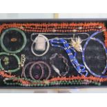 An assortment of jewellery including two garnet bangles with earrings, bead necklaces, a jade