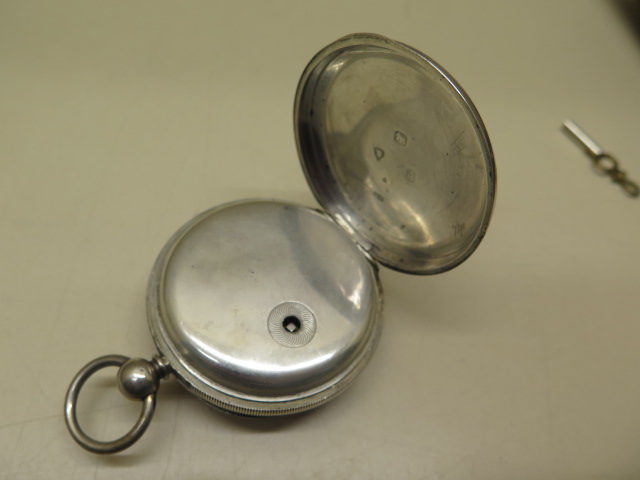 A silver pocket watch with 5.2cm case in running order, generally good some wear to case, with key - Image 3 of 4