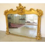 An ornate gilt over mantle mirror, 130cm tall x 152cm wide, in need of some restoration