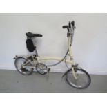 A Brompton folding bicycle with 16" wheels, lock and puncture repair kit and pump, in good condition